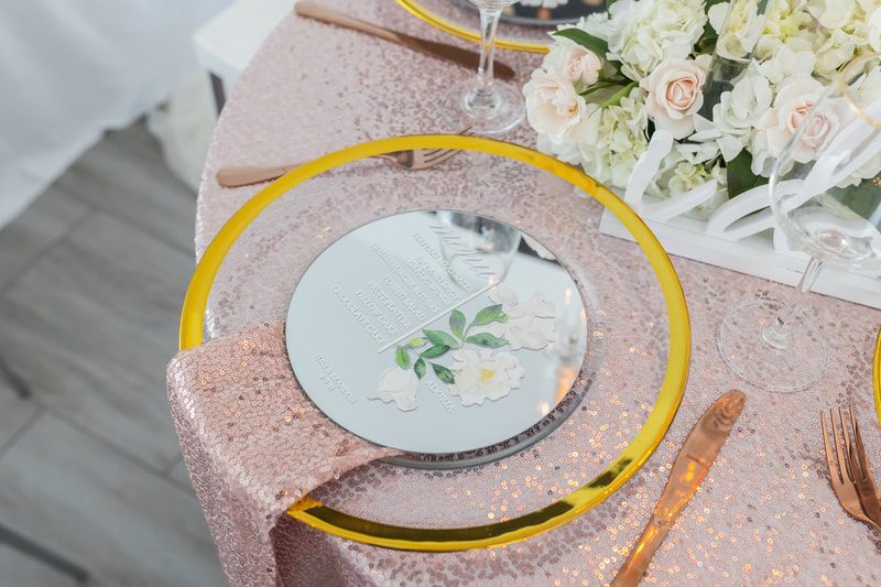 Luxury micro wedding reception place settings with rose gold sequin linens, napkins and flatware. Custom mirrored menus and gold trimmed charger plates.